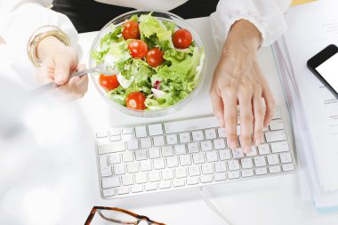 ofiste çalışırken bir salata yiyen genç kadın yaratıcı tasarımcı.