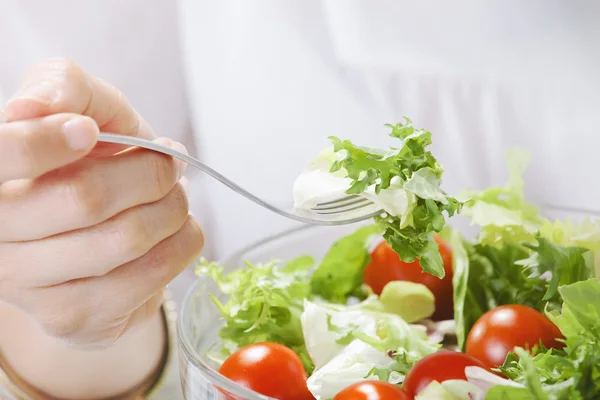 Close-up van vrouw eten van een salade in office. — Stockfoto