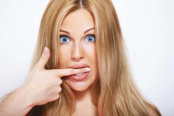 Mujer rubia feliz mordiéndole el dedo. Aislado sobre blanco . —  Fotos de Stock