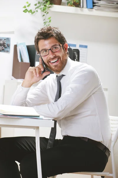 Young businessman talking on smartphone in office. — Stock Photo, Image