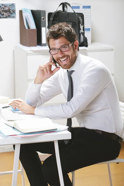 Young businessman talking on smartphone in office. — Stock Photo, Image