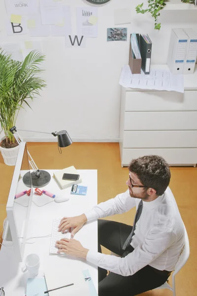 Jeune homme d'affaires tapant un ordinateur dans le bureau . — Photo