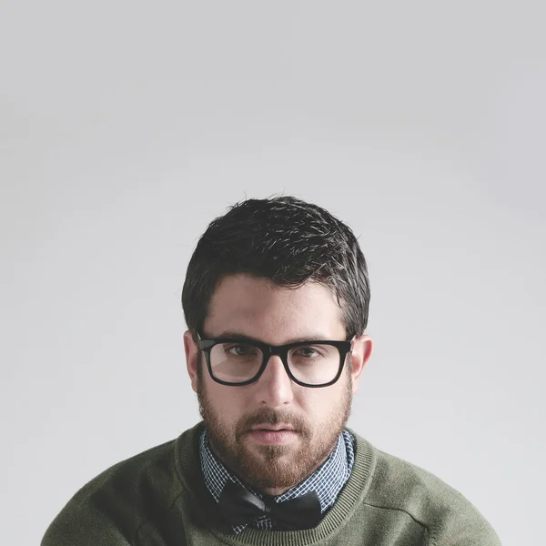 Stylish young man wearing bowtie and glasses on grey Background. — Stock Photo, Image