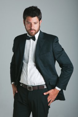 Siyah takım elbise ve yay ile şık genç adam.
