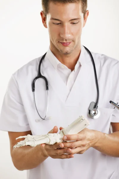 Jovem médico osteopata homem mostrando uma representação do esqueleto pé . — Fotografia de Stock