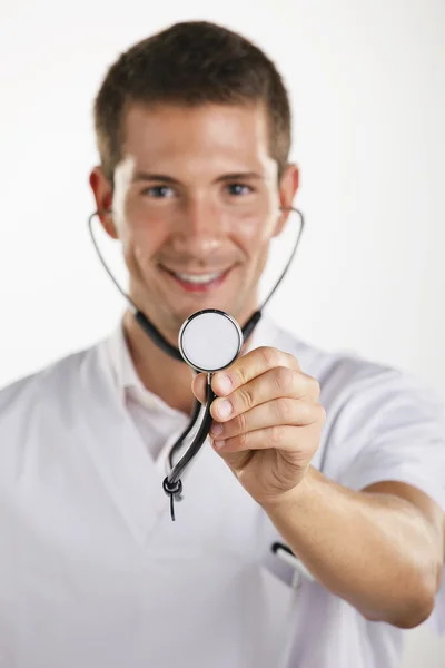 Jeune médecin homme montrant le stéthoscope. Isolé . Photos De Stock Libres De Droits