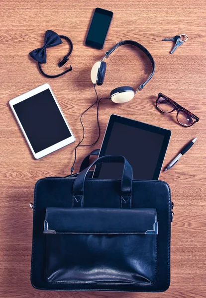 Le contenu d'une mallette d'affaires moderne sur un bureau en bois . — Photo