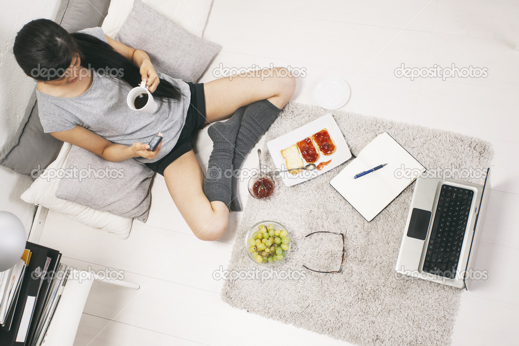 Casual asian woman having breakfast and working in home.