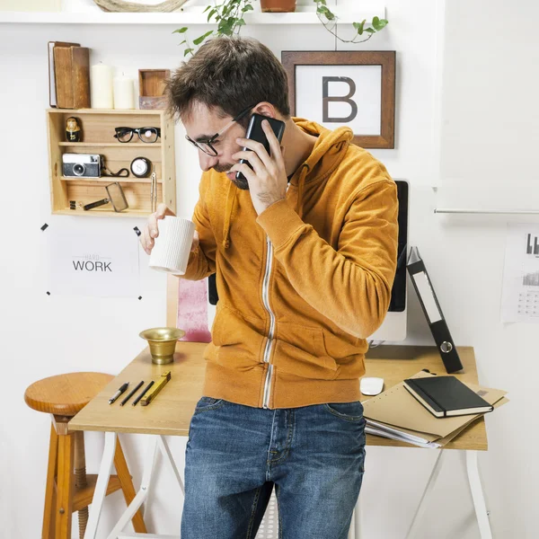 Modern kreativ människa talar med smartphone på arbetsytan. — Stockfoto