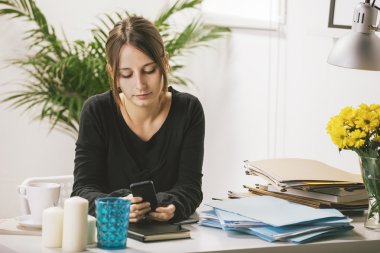 Genç casual kadın ofiste Smartphone kullanarak.