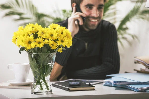 Jeune homme occasionnel parlant sur smartphone au bureau . — Photo