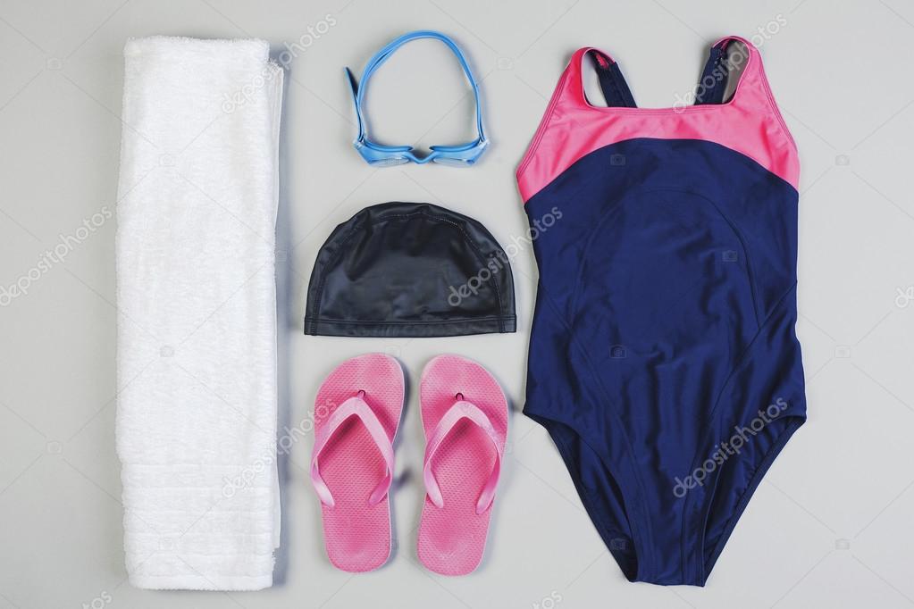 Outfit of swimming woman on grey background.
