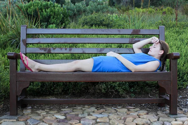 Woman lying on a Bench very tired — Stock Photo, Image