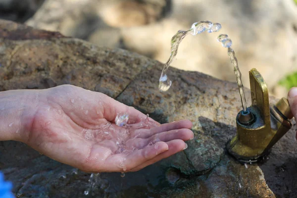 Wasser spritzt in die Hand Stockbild