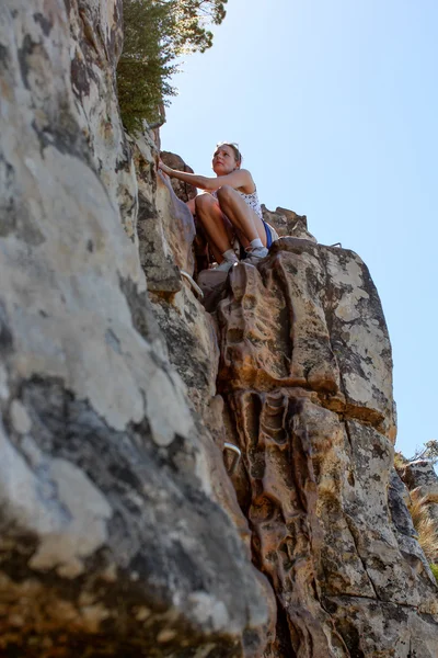 Vrouw klimmen lions head — Stockfoto