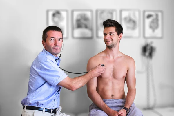 Médico haciendo un examen de los pulmones con un estetoscopio —  Fotos de Stock