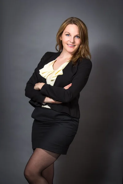 Businesswoman in front of a grey background — Stock Photo, Image