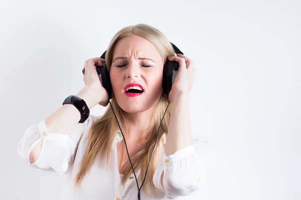 Unga blonda kvinnan höra musik med hörlurar — Stockfoto