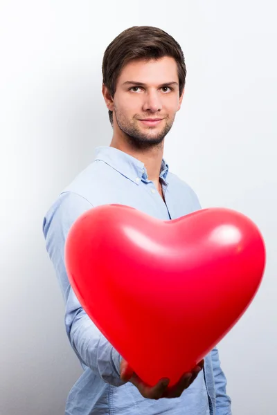 Man holding a red heart balloon — Stock Photo, Image