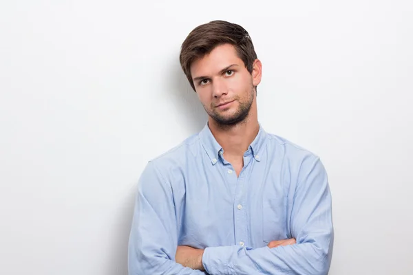 Young man with folded arms looking serious — Stock Photo, Image