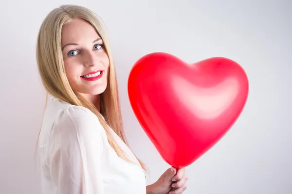 Femme tenant un ballon à coeur rouge — Photo