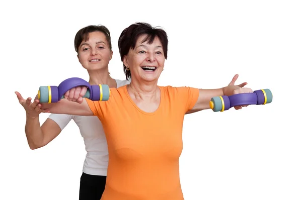 Treinador auxiliando a mulher idosa no exercício — Fotografia de Stock