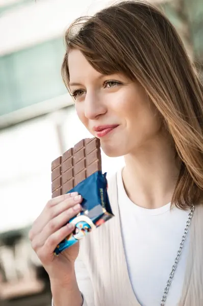 Mujer joven comiendo chocolate —  Fotos de Stock