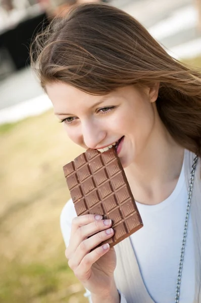 Ung kvinna äta choklad — Stockfoto