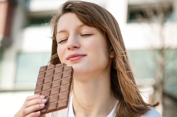 チョコレートを食べる若い女性 — ストック写真