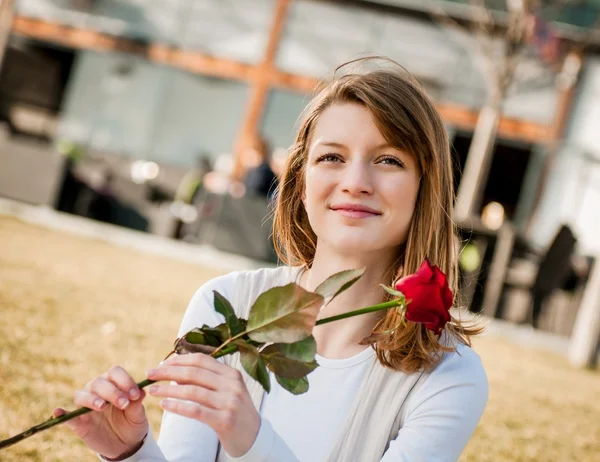 Młoda kobieta z czerwoną różą — Zdjęcie stockowe