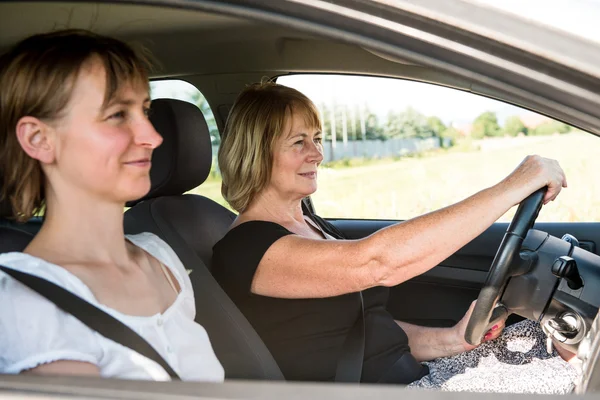 Senior vrouw met dochter rijden auto — Stockfoto