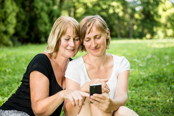 Senior mother and daughter with smartphone — Stock Photo, Image