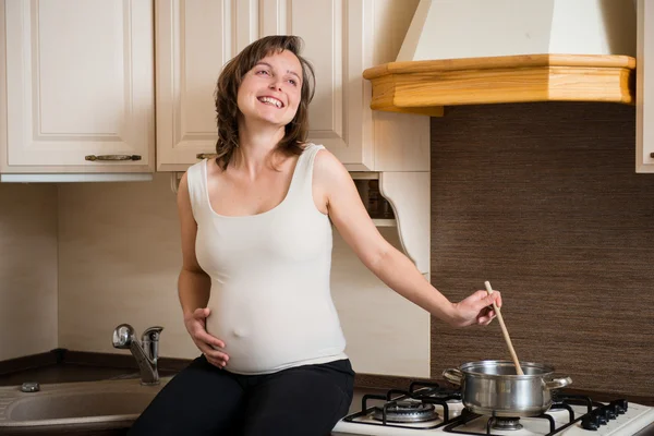 Pregnant woman cooking — Stock Photo, Image