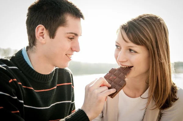 Ungt par i locve äta choklad — Stockfoto