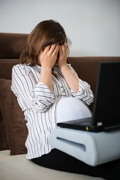 Werkende zwangere vrouw met hoofdpijn — Stockfoto