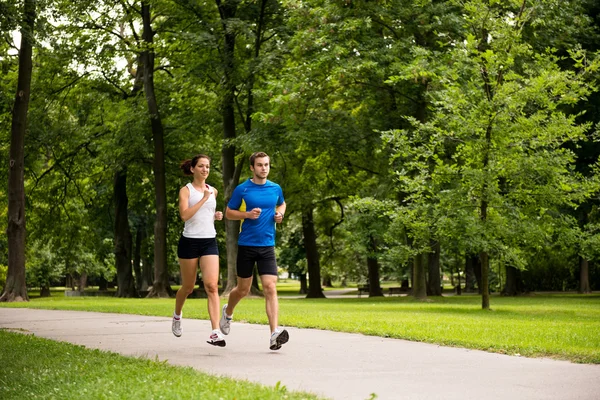 Gemeinsam joggen - junges Paar läuft lizenzfreie Stockbilder