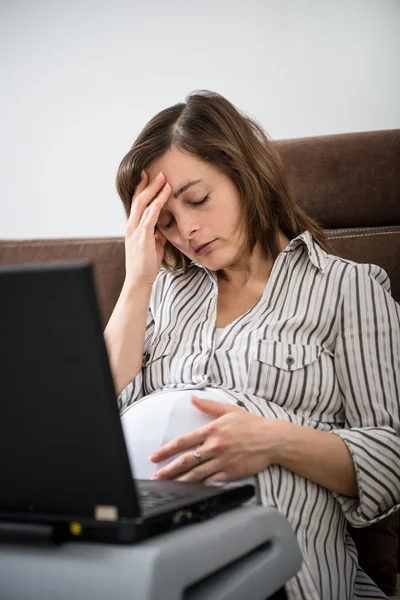 Werkende zwangere vrouw met hoofdpijn — Stockfoto