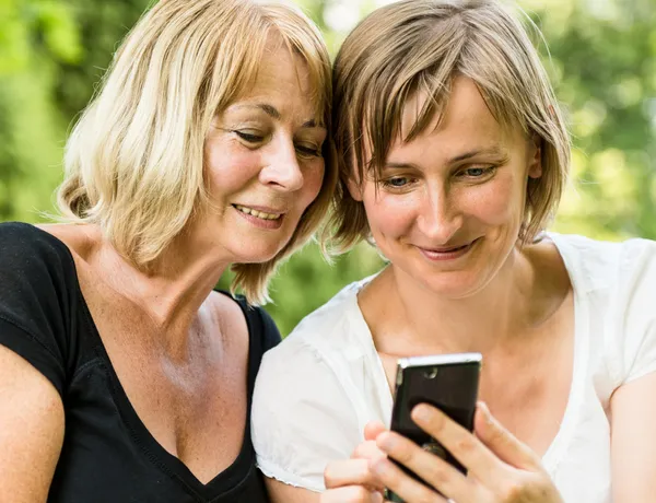 高级的母亲和女儿与智能手机 — 图库照片