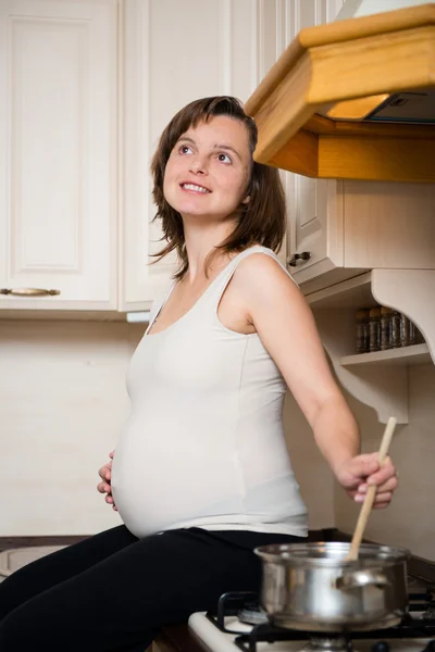 Pregnant woman cooking — Stock Photo, Image