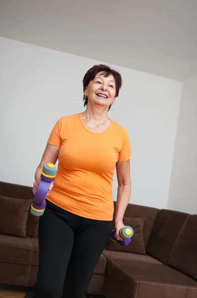 Mulher sênior exercitando com sinos — Fotografia de Stock