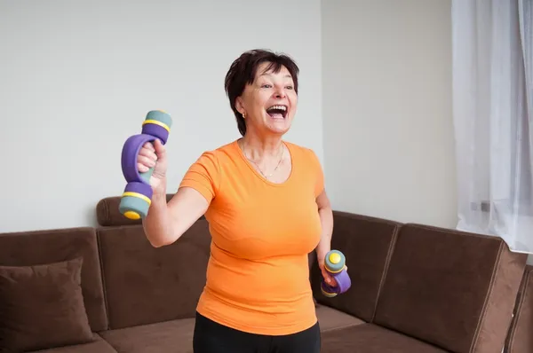 Senior woman exercising with barbells — Stock Photo, Image