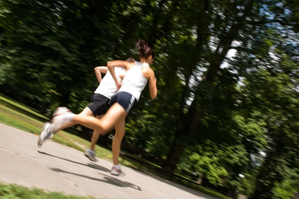 Unga par jogging - rörelse blurr — Stockfoto