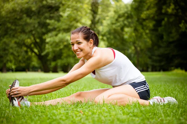 Dehnübungen - Sportlerin im Freien — Stockfoto