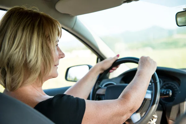 Oudere vrouw die auto rijdt — Stockfoto