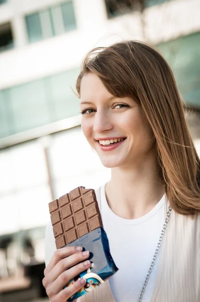 Mladá žena jíst čokoládu — Stock fotografie