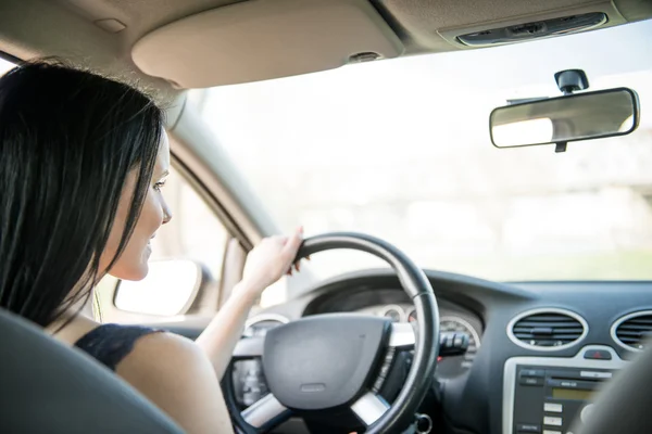 Femme aux cheveux noirs conduisant une voiture — Photo