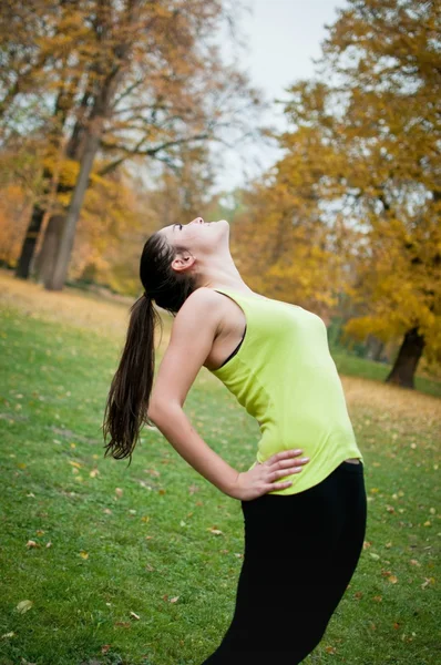 Woman performs stretching before sport outside — Stock Photo, Image