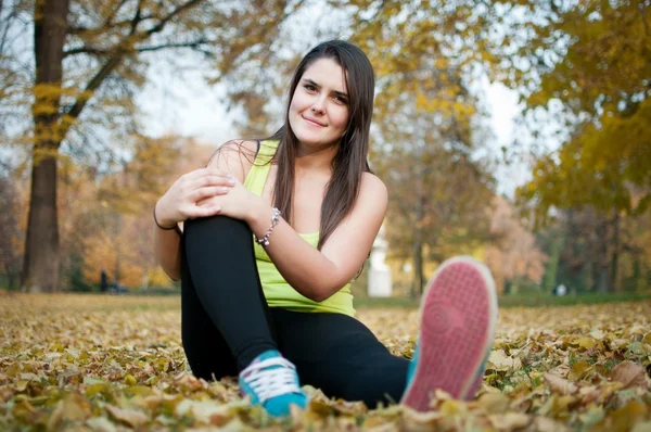 Koppla av - idrottskvinna sitter i gräset — Stockfoto