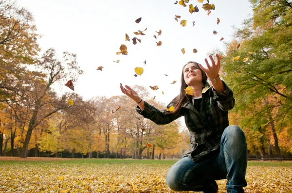 Happy life - woman throwing leaves in fall — Stock Photo, Image