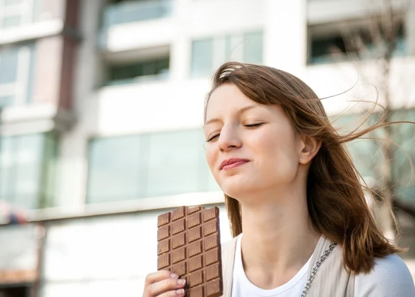 Jovem mulher comendo chocolate — Fotografia de Stock